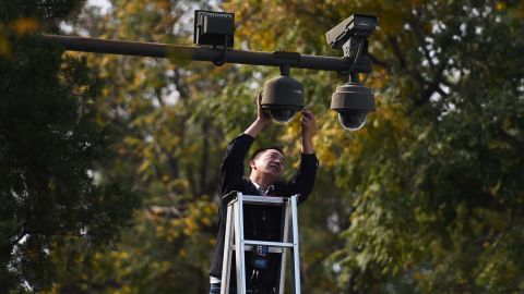 A worker adjusts security cameras on the edge of Tiananmen Square in Beijing on September 30, 2014.
