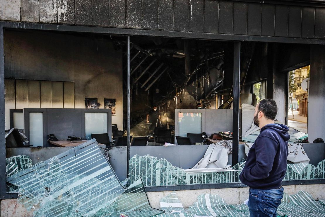 People inspect a bank set ablaze overnight by some protesters following a demonstration in Tripoli.