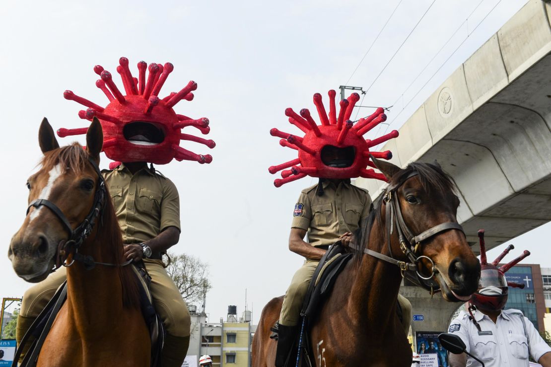 Police personnel wearing coronavirus-themed helmets ride on horses as they participate in a awareness campaign in Secunderabad, the twin city of Hyderabad, on April 2, 2020. 
