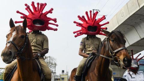 Police personnel wearing coronavirus-themed helmets ride on horses as they participate in a awareness campaign in Secunderabad, the twin city of Hyderabad, on April 2, 2020. 