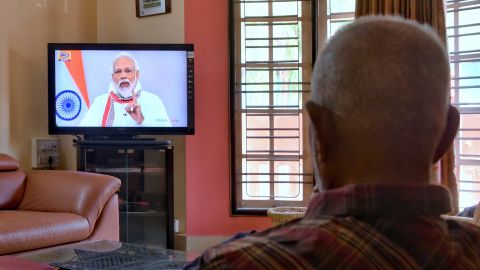 A senior citizen watches Modi address the nation on a television broadcast during India's government-imposed coronavirus lockdown.