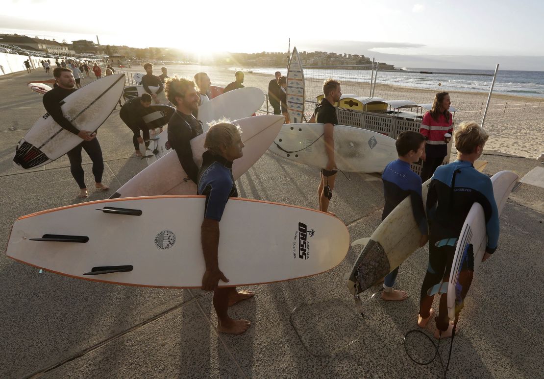 Surfers wait for officials to open Bondi Beach in Sydney on April 28 as coronavirus pandemic restrictions are eased. The beach is open to swimmers and surfers to exercise only. 