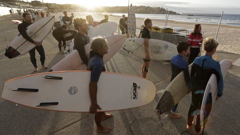 Surfers wait for officials to open Bondi Beach in Sydney on April 28 as coronavirus pandemic restrictions are eased. The beach is open to swimmers and surfers to exercise only. 
