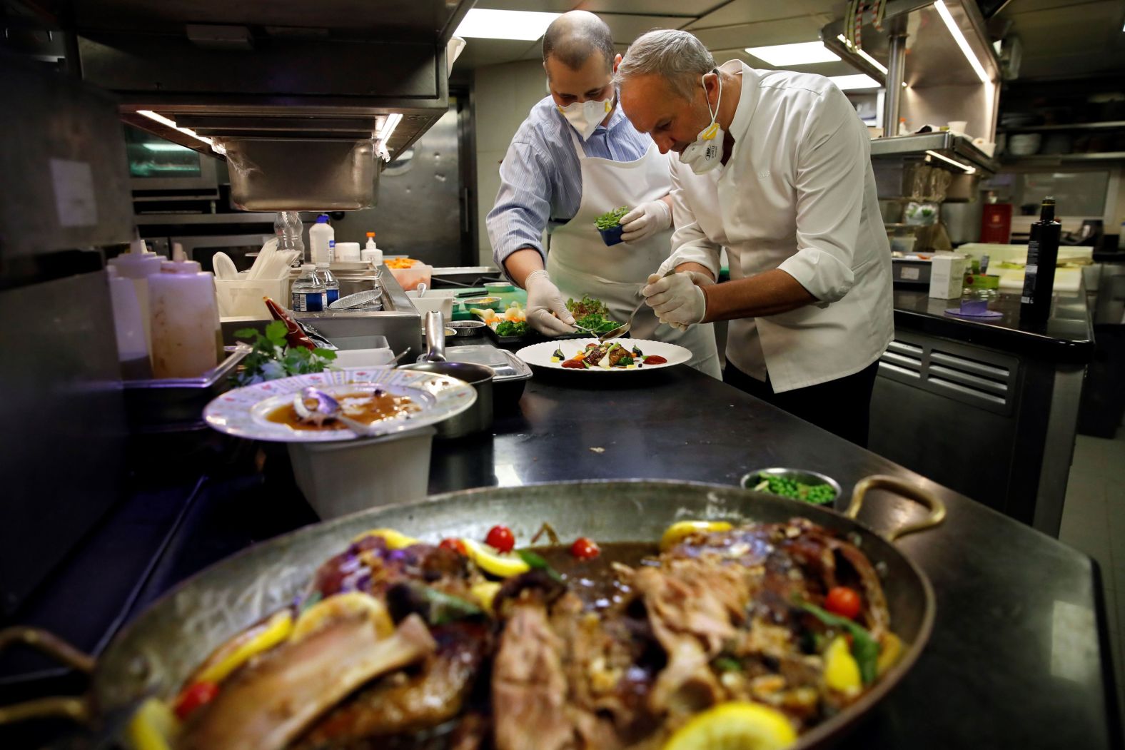 Michelin-starred chefs Alan Taudon, left, and Christian Le Squer cook for employees of a Parisian hospital on April 11.