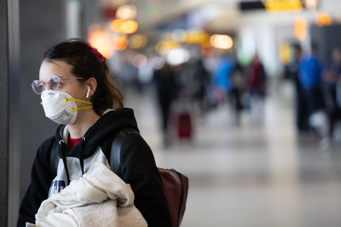  A passenger wearing a mask prepares to board a flight at the Seattle-Tacoma International Airport on March 15. 