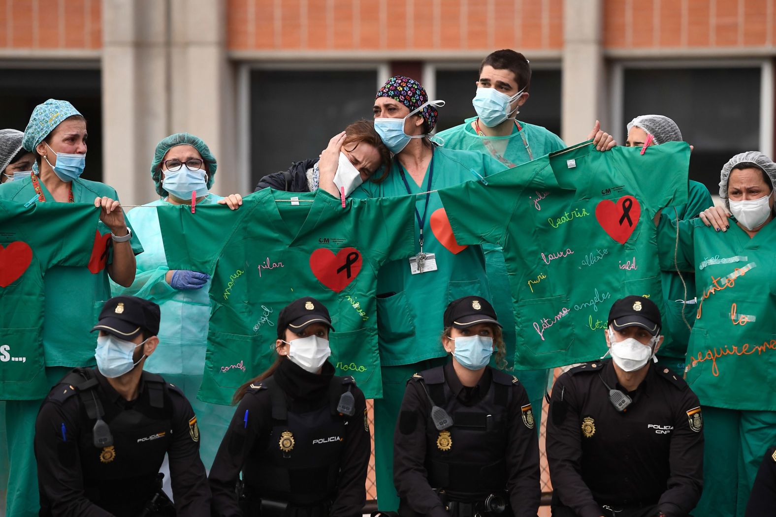 Health-care workers cry April 10 during a memorial for Esteban, a nurse they worked with at the Severo Ochoa Hospital in Leganes, Spain. Esteban was a casualty of the coronavirus pandemic. 