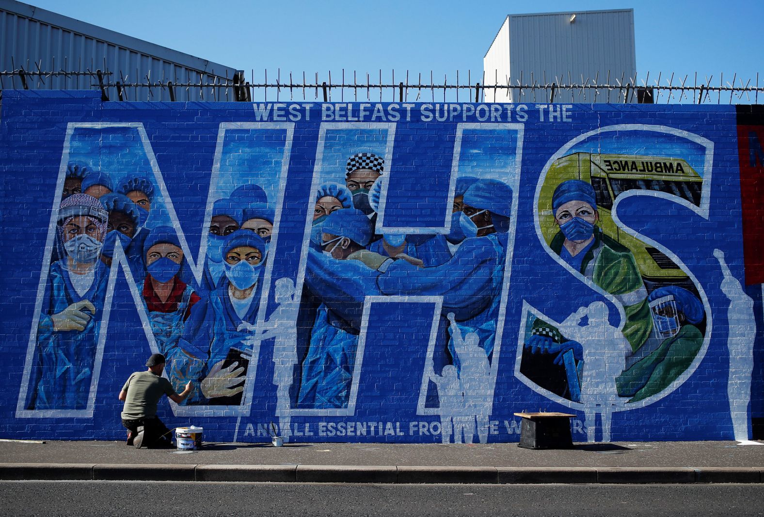 Artist Marty Lyon works on a mural he and Micky Doherty created to honor health-care workers in Belfast, Northern Ireland, on April 21.