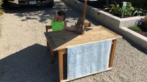 Callaghan McLaughling sits at his joke stand and waits for people to walk or drive by.