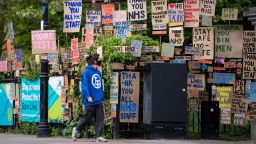 LONDON,  ENGLAND - APRIL 25: A woman in a face mask walks past signs in support of the NHS and key workers in East London on April 25, 2020 in London, England. The British government has extended the lockdown restrictions first introduced on March 23 that are meant to slow the spread of COVID-19. (Photo by Justin Setterfield/Getty Images)