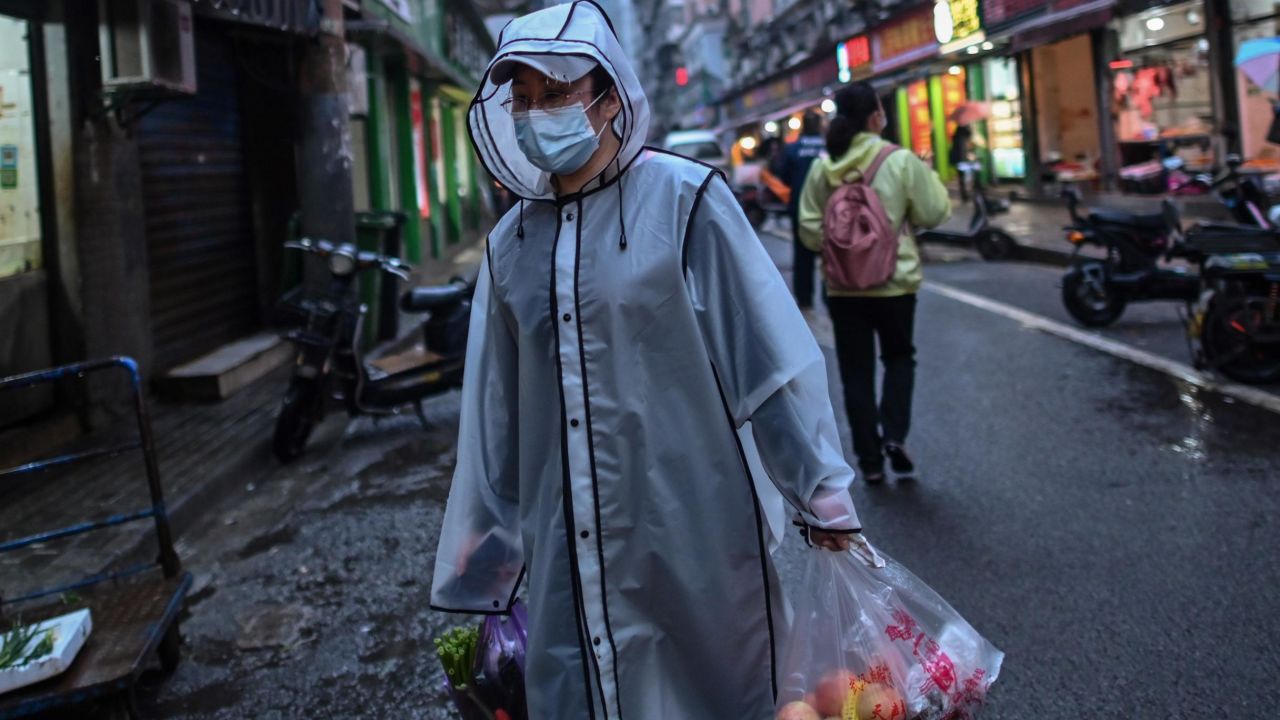 A person wearing a face mask as a preventive measure against the spread of the COVID-19 novel coronavirus carries groceries in a neighbourhood in Wuhan in China's central Hubei province on April 20.