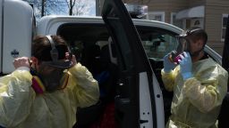 Paramedics Alex Storzillo and Jim Incorvaia adjust their respirators before entering a house in Paterson, N.J. Since the beginning of the COVID-19 outbreak, the pair has treated each call as a potential source of coronavirus infection.