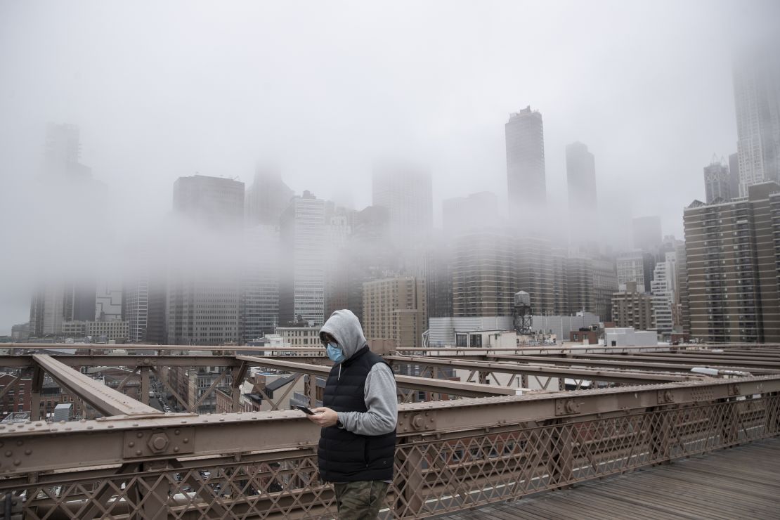 A man wearing a mask walks the Brooklyn Bridge in the midst of the coronavirus outbreak in New York City.
