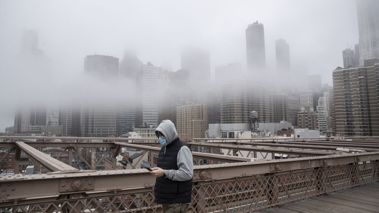 A man wearing a mask walks the Brooklyn Bridge in the midst of the coronavirus outbreak in New York City.