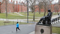A runner crosses Harvard Yard on March 23, 2020 in Cambridge, Massachusetts. Students were required to be out of their dorms no later than March 15 and finish the rest of the semester online due to the ongoing COVID-19 pandemic.