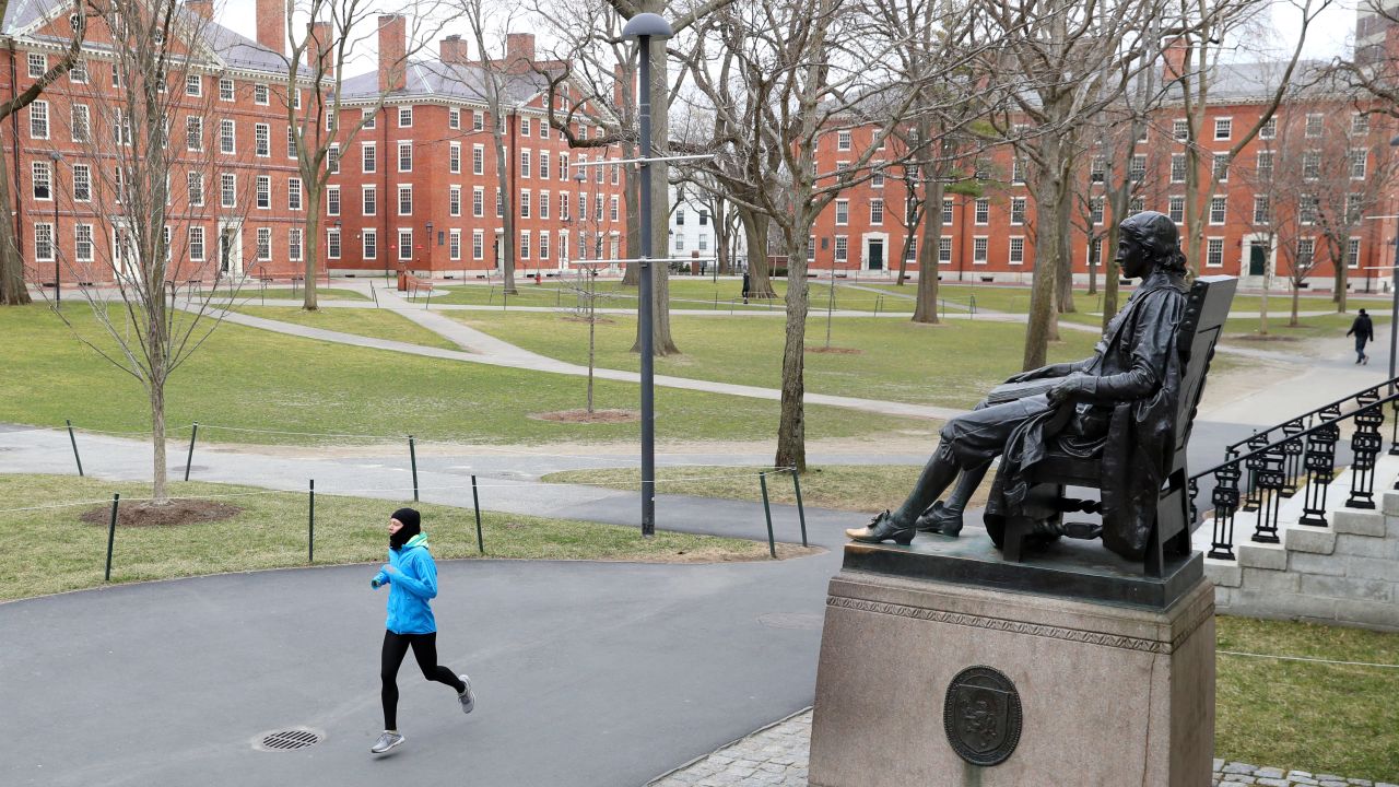 A runner crosses an empty Harvard Yard last month, after students were asked to finish the semester online.