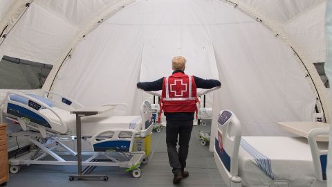 Red Cross volunteer Stephane Corbeil adjusts an opening in a tent at a mobile hospital at Jacques Lemaire Arena in the Montreal suburb of LaSalle.