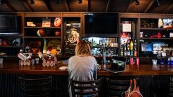 A customer sits at the bar of a BBQ restaurant amid the coronavirus pandemic in Atlanta, Georgia on April 27, 2020. 