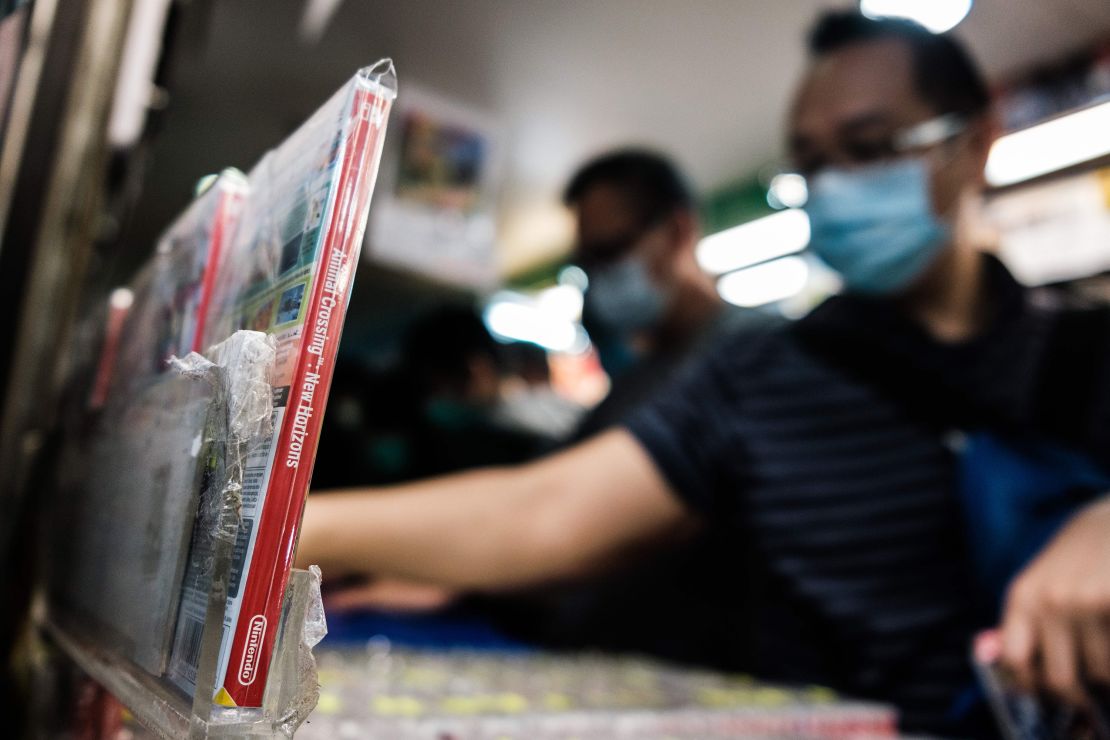 A copy of Nintendo computer game Animal Crossing: New Horizons (L) is displayed in a shopping mall as customers browse other games while wearing face masks, as a precautionary measure against the COVID-19 coronavirus, in Hong Kong on April 10, 2020. (Photo by Anthony Wallace/AFP/Getty Images)