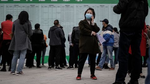 A job applicant makes a call at an on-site job fair in Wuhan last month. The landscape for job hunters might get even more difficult in the coming weeks as about 8.7 million people graduate from colleges and universities. 