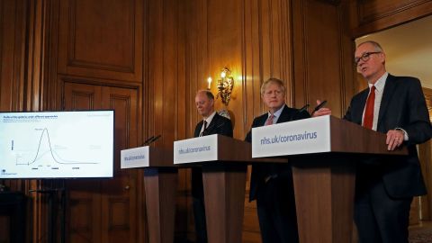 Boris Johnson, center, is flanked by the Chief Medical Officer for England, Chris Whitty, left, and Chief Scientific Adviser Patrick Vallance at a March 12 news conference.
