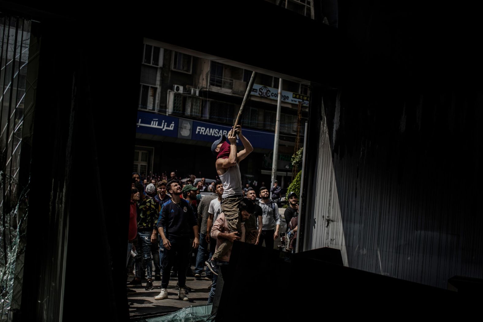 Protesters vandalize a bank in Tripoli's Al-Nour Square.