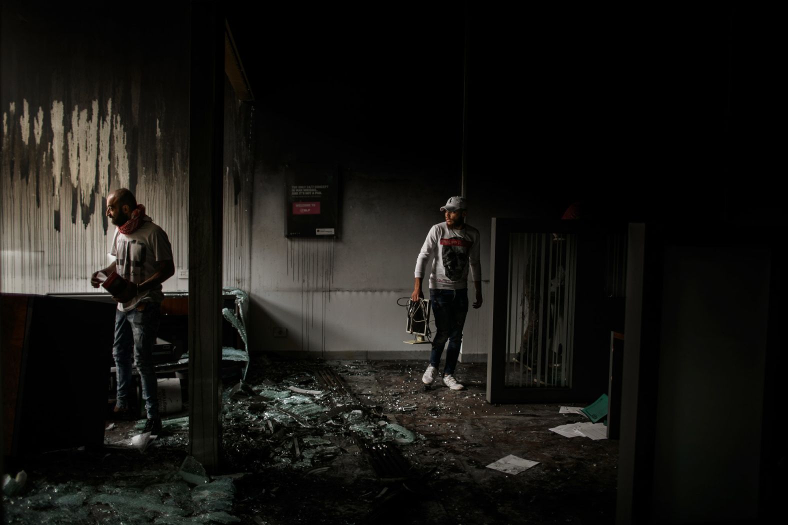 Men are seen inside a vandalized bank in Tripoli.