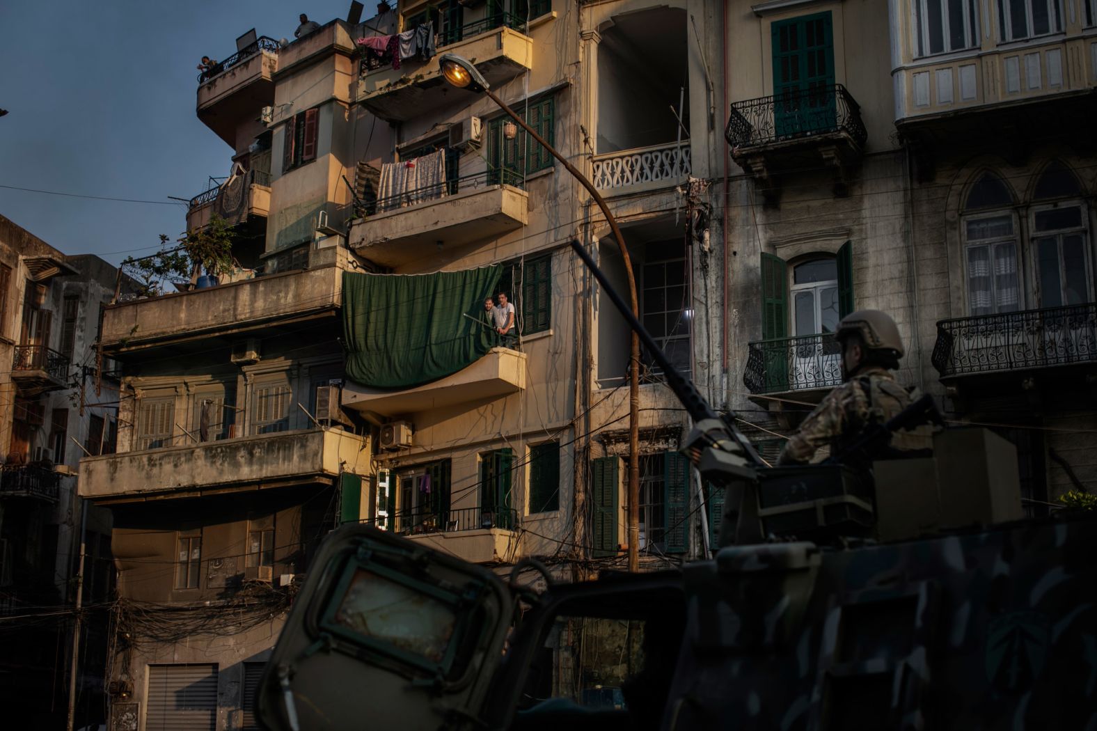 People watch the clashes from a balcony in Tripoli.