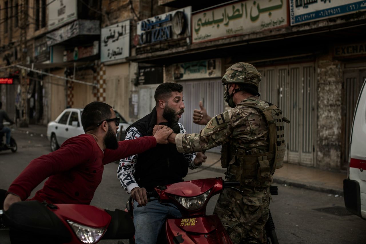A soldier stops a man on a motorcycle during Tuesday's clashes.