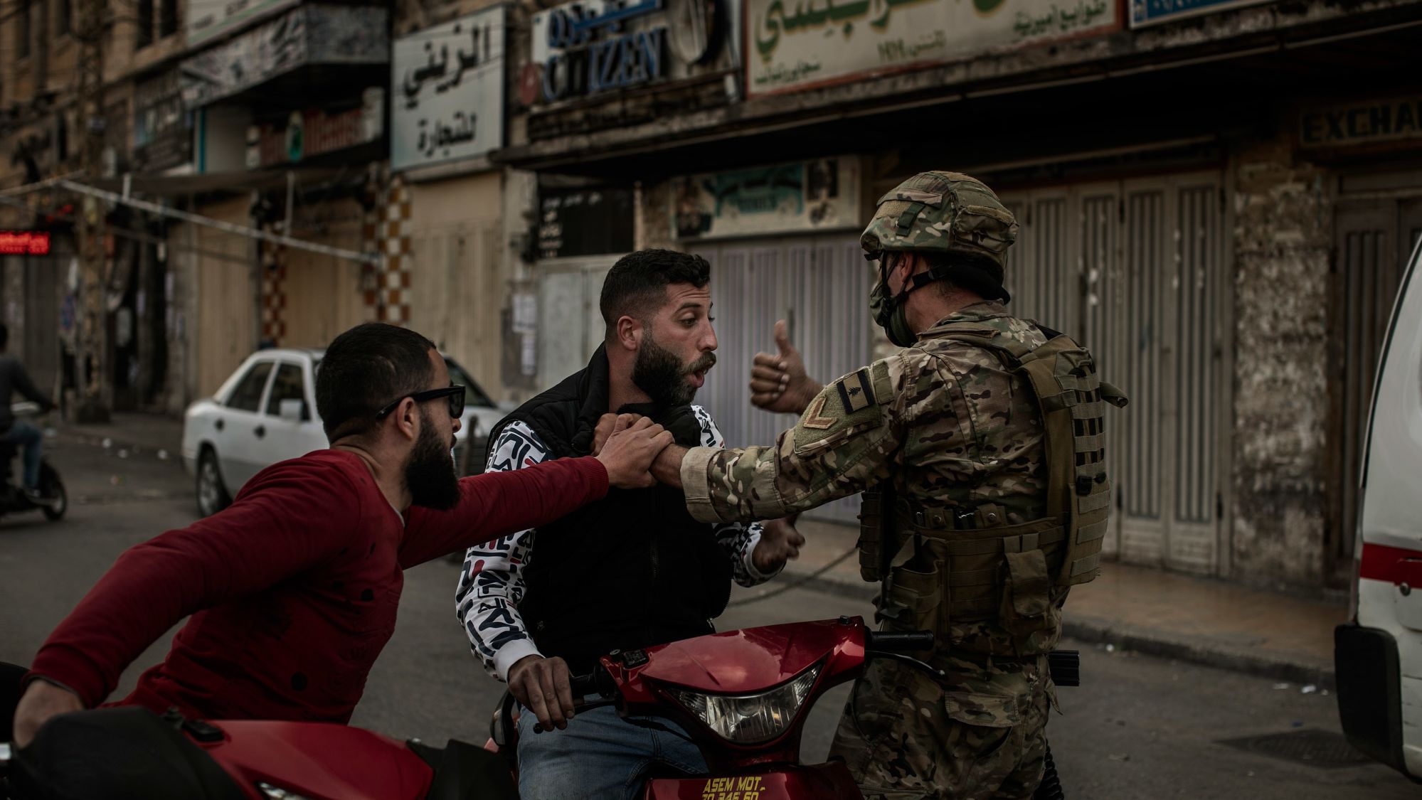 A soldier stops a man on a motorcycle during Tuesday's clashes.