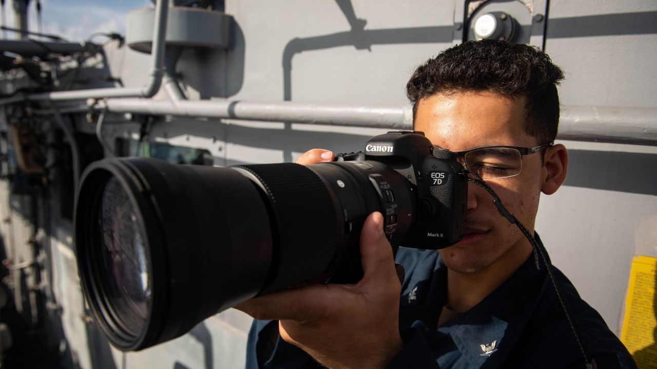 US Navy Spec. Kevin Rodruigez, from Hartford, Md., takes a picture of a surface contact from aboard the guided-missile cruiser USS Bunker Hill on Wednesday near the Spratly Islands in the South China Sea.
