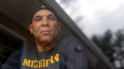Chuck Christian, of Randolph, Mass., the first former Michigan football player to publicly say that a team doctor abused him, looks through a window in his home while standing for a photograph, Wednesday, April 22, 2020, in Randolph. Christian, a 60-year-old artist, said during a videoconferencing interview Wednesday, April 22, that the late Dr. Robert Anderson gave him unnecessary rectal exams before he played for the Wolverines during 1977-80 seasons. (AP Photo/Steven Senne)