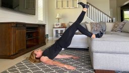Dana Santas gets off her couch and demonstrates the single-leg variation on the elevated hip bridge.