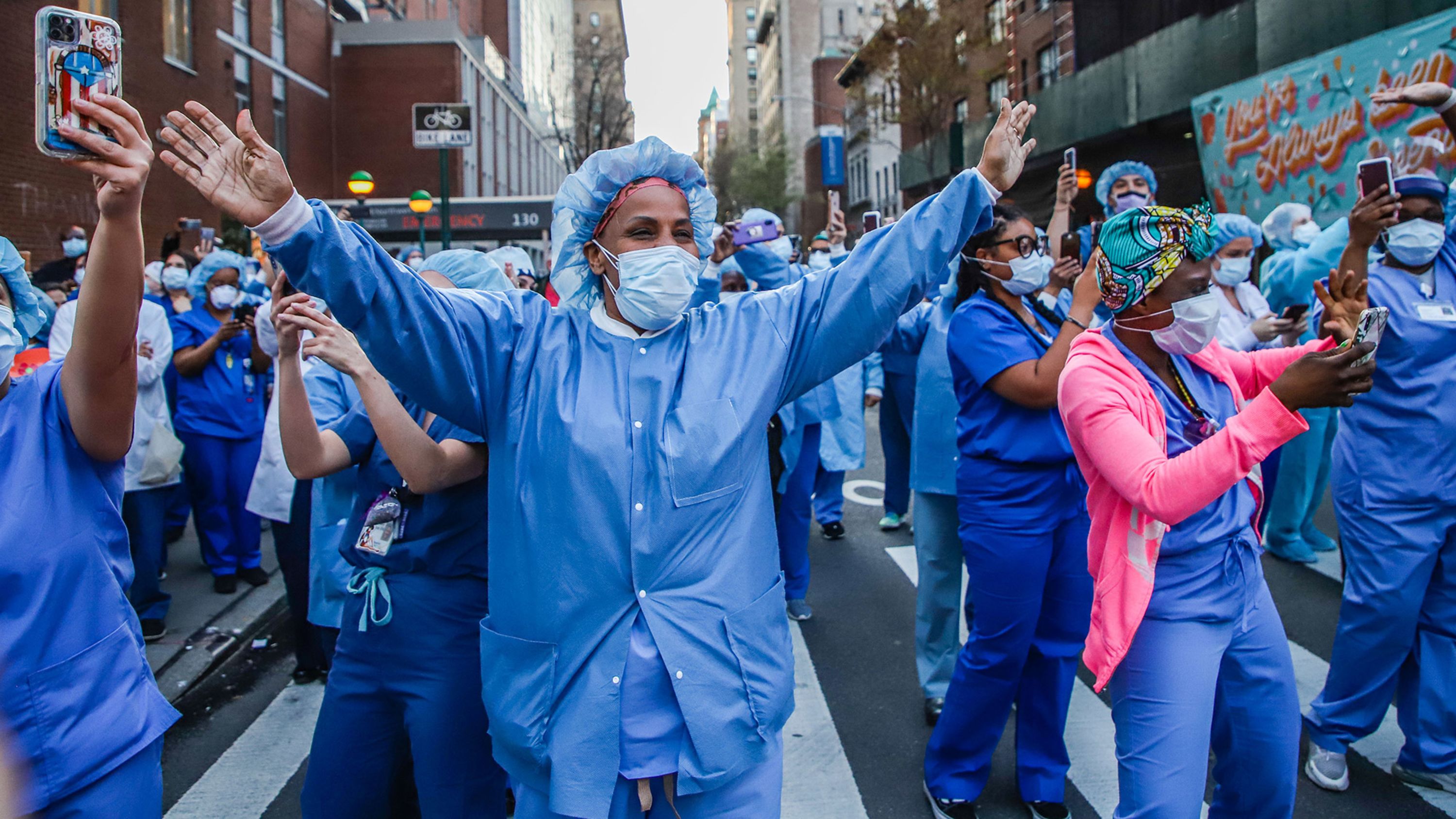 Health-care workers wave back to people applauding them in New York City on April 15.
