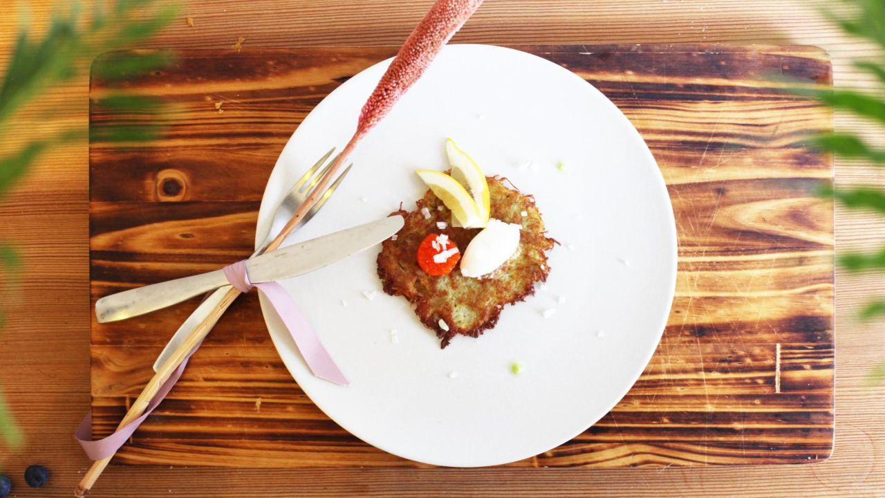 A starter dish called R?raka, Swedish style hash brown, smetana (sour cream), seaweed caviar, and wood plucked sorrel.