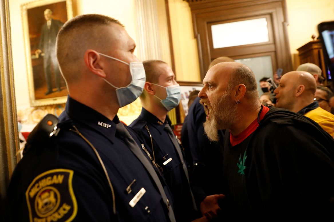 Michigan state police prevent protesters from entering the chamber of the Michigan House of Representatives on Thursday, April 30. The protesters are unhappy with the state's stay-at-home order. Gov. Gretchen Whitmer recently <a href="https://www.cnn.com/2020/04/24/politics/gretchen-whitmer-michigan-stay-at-home/index.html" target="_blank">extended the order</a> through May 15, though restrictions were relaxed so some businesses could reopen.