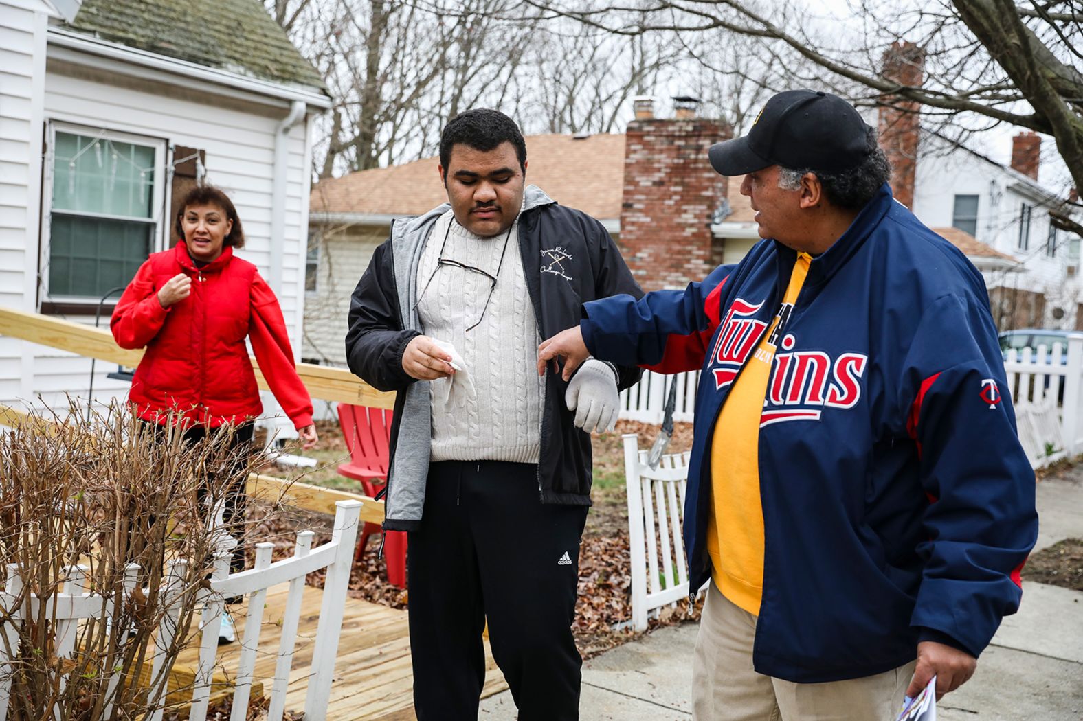 Lisa Kincade, left, stands with her son Willie as her husband, Mike, adjusts Willie's coat in front of their home in Roslindale, Massachusetts, on April 4. Willie, who has autism, was hoping to get his diploma this spring. But the pandemic made his future plans uncertain.