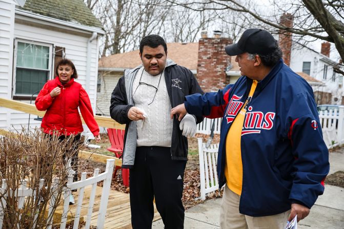 Lisa Kincade, left, stands with her son Willie as her husband, Mike, adjusts Willie's coat in front of their home in Roslindale, Massachusetts, on April 4. Willie, who has autism, was hoping to get his diploma this spring. But the pandemic made his future plans uncertain.