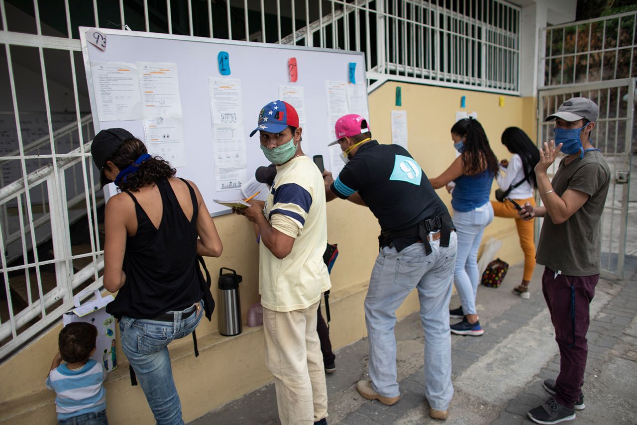 People in Caracas, Venezuela, who do not have internet access at home gather in front of a school to copy their children's work for the week on April 27.