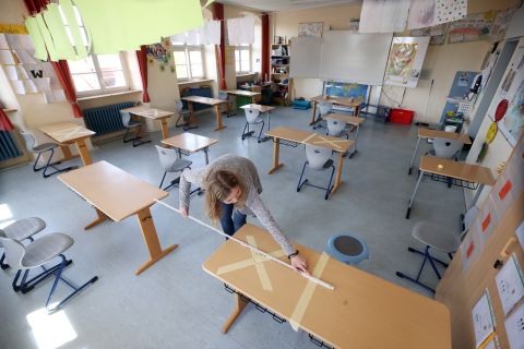 A woman measures the appropriate social-distancing space on April 21 before reopening the Schloss-Schule Elementary School in Heppenheim, Germany.