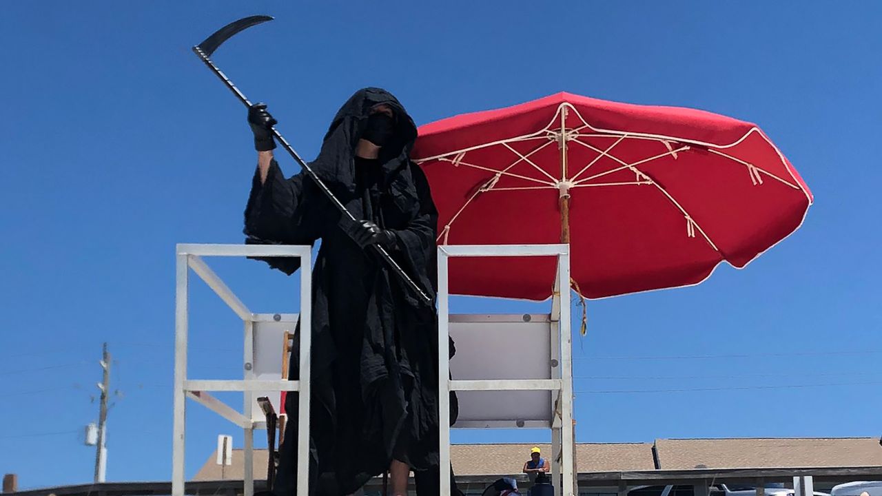 Daniel Uhlfelder, a Florida lawyer, is haunting Florida beaches dressed as the Grim Reaper to protest their reopening, which he believes is premature.