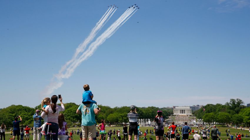 People view the U.S. Navy Blue Angels and U.S. Air Force Thunderbirds as they fly over the National Mall in Washington, Saturday, May 2, 2020. The flyover was in salute to first responders in the fight against the coronavirus pandemic. (AP Photo/Patrick Semansky)