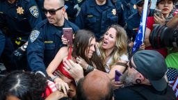 In this Friday, May 1, 2020 photo, protester Heidi Munoz Gleisner, center left, is removed from a demonstration against California Gov. Gavin Newsom's stay-at-home order by California Highway Patrol officers after they ordered a crowd of people to leave the Capitol grounds in Sacramento, Calif. 