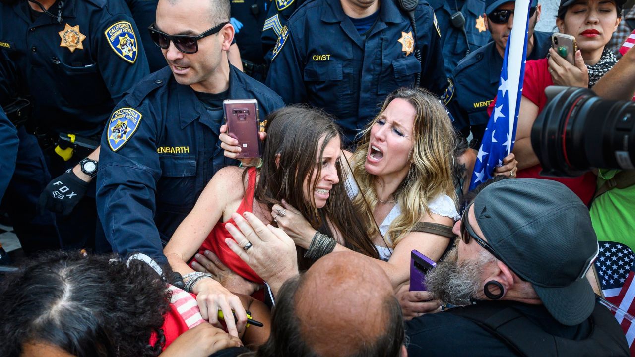 Heidi Munoz Gleisner, center left, is removed from a protest against California's stay-at-home order.
