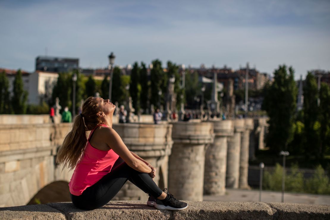 A woman basks in the sun at the Toledo bridge in Madrid, Spain, on Sunday, May 3.