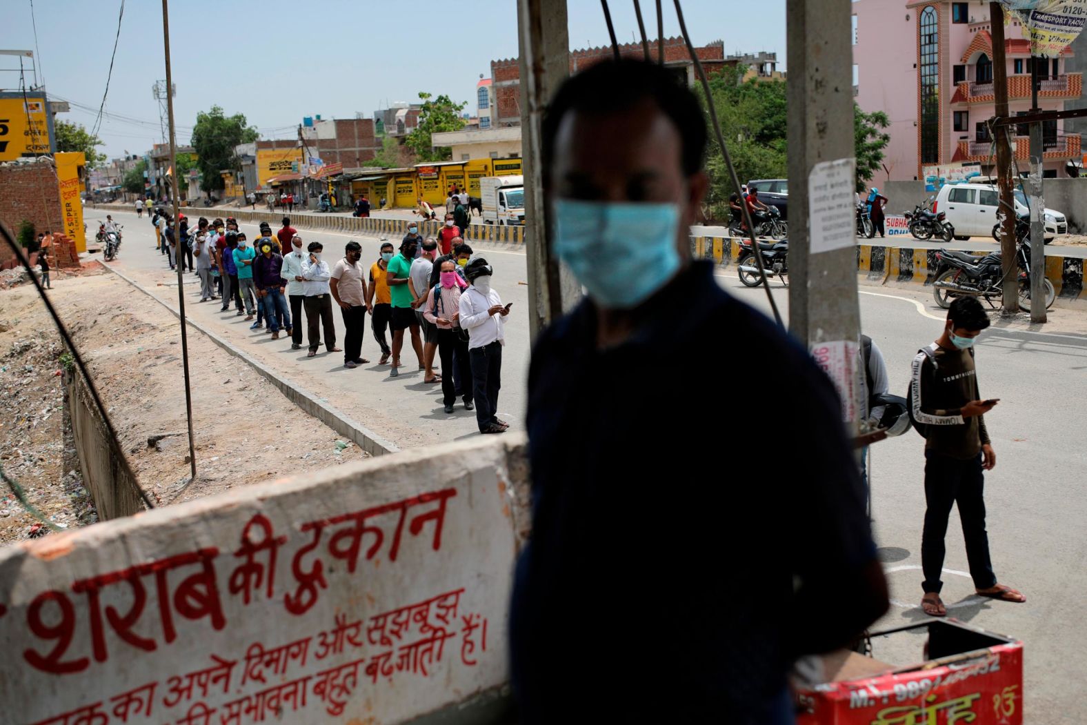 People line up at a reopened liquor shop on the outskirts of New Delhi on May 4. The six-week lockdown in India, which was supposed to end on May 4, was extended two weeks with a few relaxations.