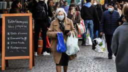 A woman wearing a protective facemask walks in the Mouffetard street as she does her grocery shopping during the food market, on May 2, 2020 in Paris, during the 47th day of a strict lockdown in France aimed at curbing the spread of the COVID-19 (the novel coronavirus). (Photo by Alain JOCARD / AFP) (Photo by ALAIN JOCARD/AFP via Getty Images)