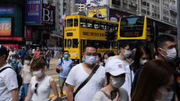 Pedestrians wearing protective masks cross Hennessy Road in the Causeway Bay district in Hong Kong, China, on Friday, May 1, 2020. 