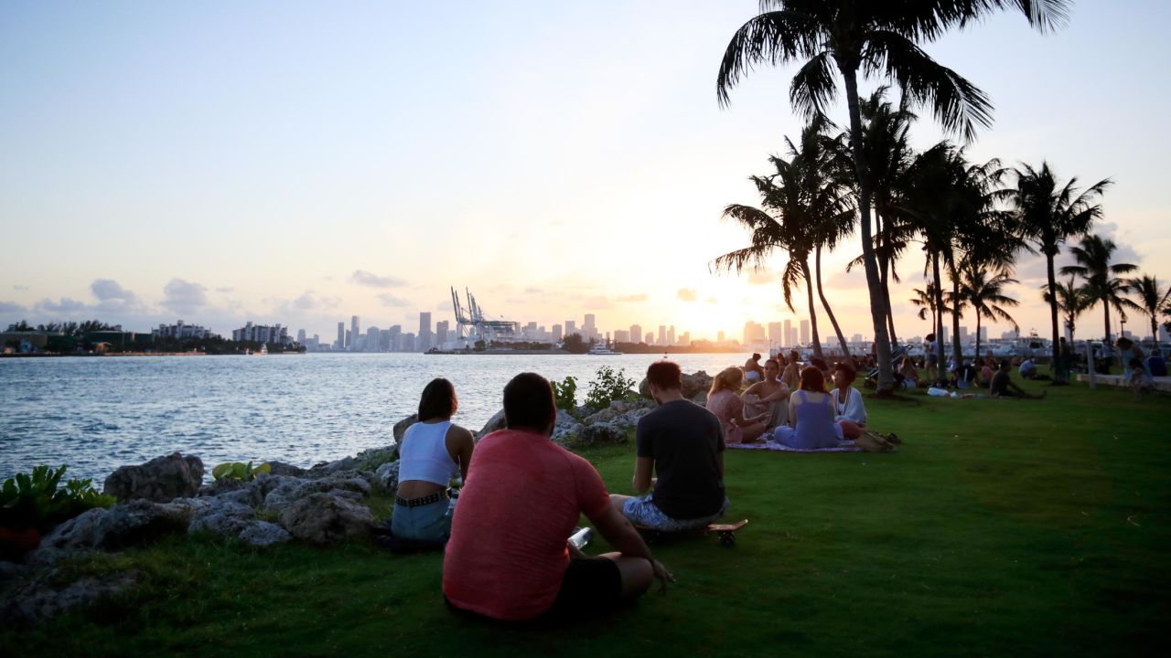 MIAMI BEACH, FLORIDA - APRIL 29: People gather for sunset in South Pointe Park on April 29, 2020 in Miami Beach, Florida.  The city of Miami Beach partially reopened parks and facilities including golf courses, tennis courts and marinas as it begins easing restrictions made due to the COVID-19 pandemic. (Photo by Cliff Hawkins/Getty Images)