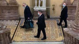 Senate Minority Leader Chuck Schumer, D-N.Y., wears a mask as he and his aides arrive on Capitol Hill as the Senate reconvenes on Monday, May 4, 2020. 