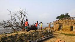 TOPSHOT - In this photo taken on May 18, 2019, Indian children play on the coast affected by erosion on the Ghoramara island around 110 km south of Kolkata, ahead of the 7th and final phase of India's general election. - Residents on Ghoramara fear that the votes they cast on May 19 in India's election may be the last before their island sinks into the Bay of Bengal -- a victim of climate change's growing toll. (Photo by DIBYANGSHU SARKAR / AFP) / To go with story 'INDIA-VOTING-ELECTION-ENVIRONMENT-CLIMATE' by Bhuvan Bagga        (Photo credit should read DIBYANGSHU SARKAR/AFP via Getty Images)